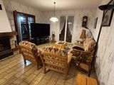 a living room with a couch, chair, television, and fireplace