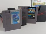 three nintendo games sitting next to each other on a table