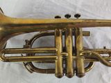 an old brass trumpet sitting on top of a white sheet