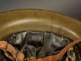 a close up of a military helmet with a leather strap
