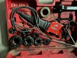 a tool in a red case that is sitting on the floor