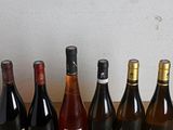 several bottles of wine are lined up on a wooden table