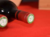 two bottles of wine sitting on a red cloth