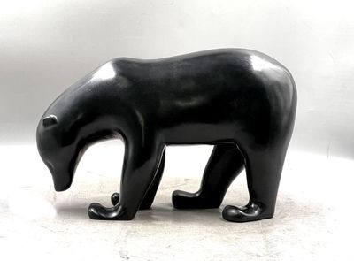 a black sculpture of a bear on a white surface