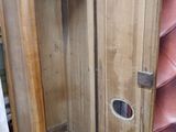 an old wooden cabinet with a glass door in it