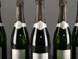 six bottles of champagne are lined up in a row on a table