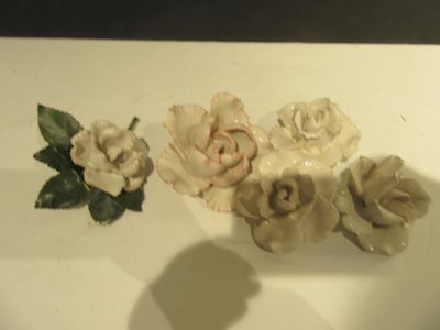 a white plate with three flowers and a green leaf on it