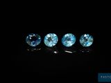 a group of three blue topazte gems sitting on top of a black surface