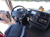 a steering wheel and dashboard of a bus on the street
