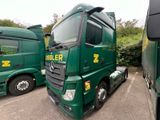two green trucks parked next to each other in a parking lot