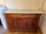 a wooden cabinet with a marble top in a room