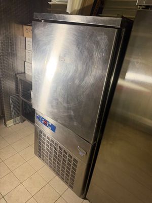 a stainless steel refrigerator in the corner of a kitchen