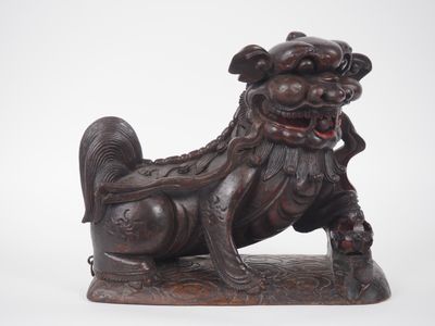 une image représentant une statue de chien assis sur un rocher