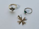 deux bagues et une bague ornée d'une pierre verte sur un fond blanc