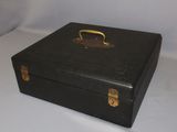 a black suitcase with a gold handle on a white surface
