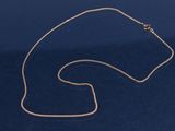 un collier plaqué or sur fond bleu