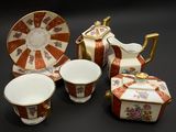 une image représentant un ensemble d'objets en porcelaine posés sur une surface noire