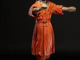 figurine of a man in a red dress with a green hat
