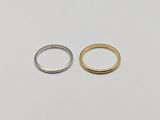 two gold and silver rings on a white surface