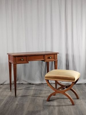 un petit bureau en bois avec un tabouret devant