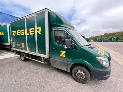 un camion vert garé sur un parking