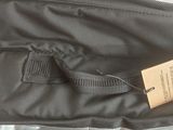 a black bag with a tag on it sitting on a bed
