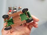 a person holding a green toy car in their hand