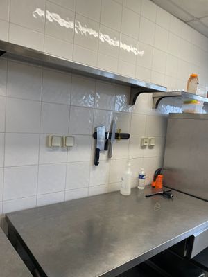 plan de travail en acier inoxydable dans une cuisine professionnelle avec du carrelage blanc