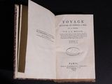 an old book opened to reveal a page of text on a black background