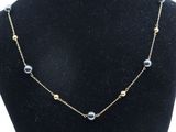 un collier de mannequin noir orné de perles et de perles dorées