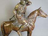 statue en bronze représentant un homme à cheval, coiffé d'un chapeau