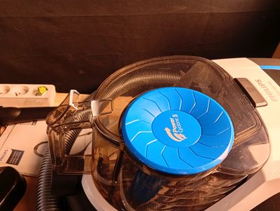 un aspirateur posé sur une table à côté d'un téléphone