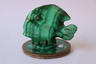 une statue représentant un poisson vert posée sur un socle en bois