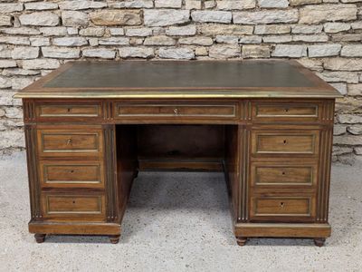 an image of a wooden desk with drawers and a stone wall in the background