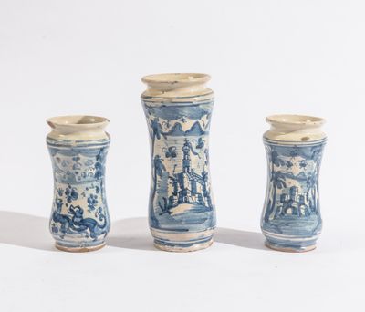 trois vases bleus et blancs posés les uns à côté des autres sur une surface blanche