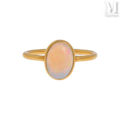 une bague en or sertie d'une pierre oplite au centre