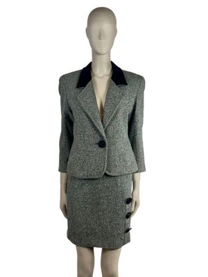the mannequin is wearing a skirt suit with a black collar