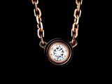 a close up of a necklace with a diamond on a chain