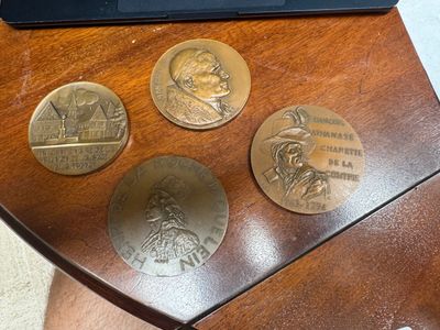 three coins on a table next to a laptop