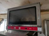 un téléviseur posé sur une cuisinière dans une cuisine