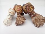 trois figurines en céramique représentant des hommes portant un chapeau et une barbe, posées sur un fond blanc