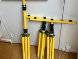 two yellow tripods are sitting on a wooden floor next to a wall