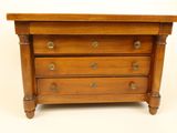 a small wooden chest of drawers on a white background
