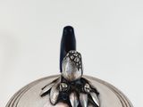 a silver container with a bird on top of it