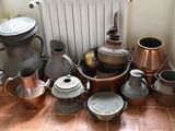 de nombreuses casseroles et poêles posées sur le sol à côté d'un radiateur