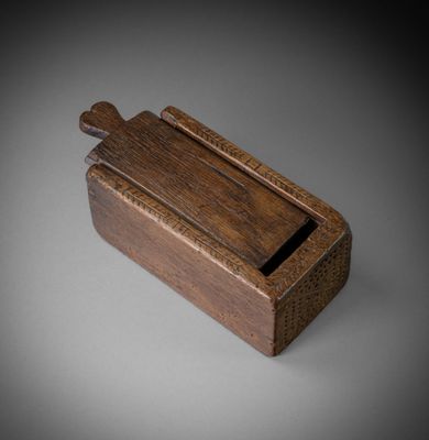 an old wooden box with a wooden handle on a gray surface