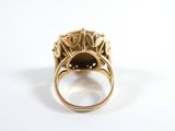 a close up of a gold ring with a black stone in it