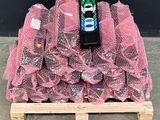 a pile of pink plastic bags on a pallet with a can of soda
