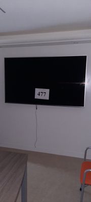 un grand téléviseur à écran plat fixé au mur dans la pièce
