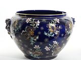 a large blue vase with flowers and birds on it